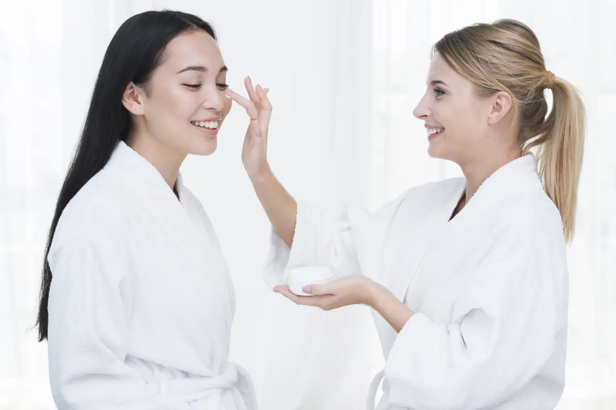 Friends using beauty cream in a spa