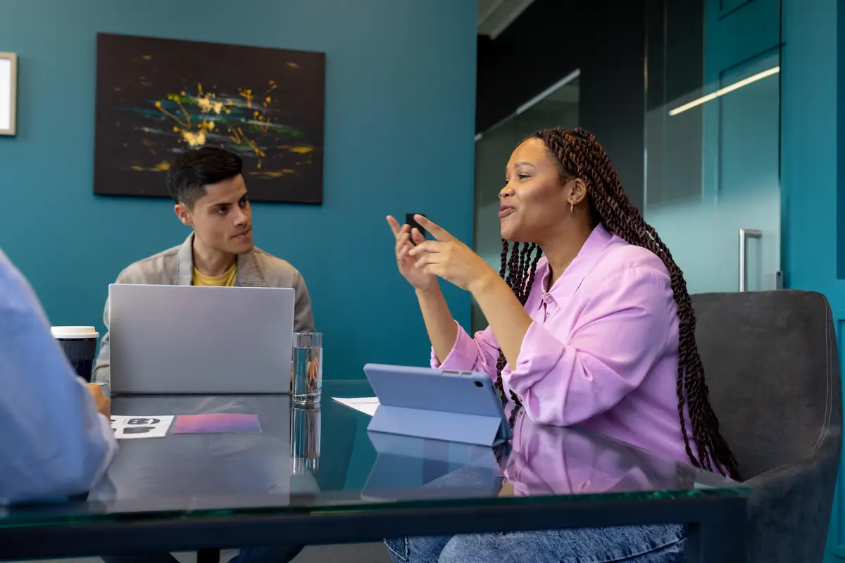Woman shows smartphone to diverse colleagues during a business startup session