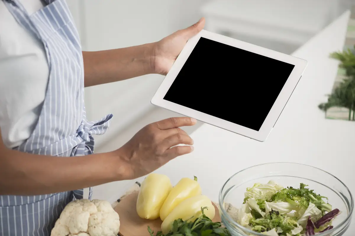 Hands holding a photo mock up next to vegetables
