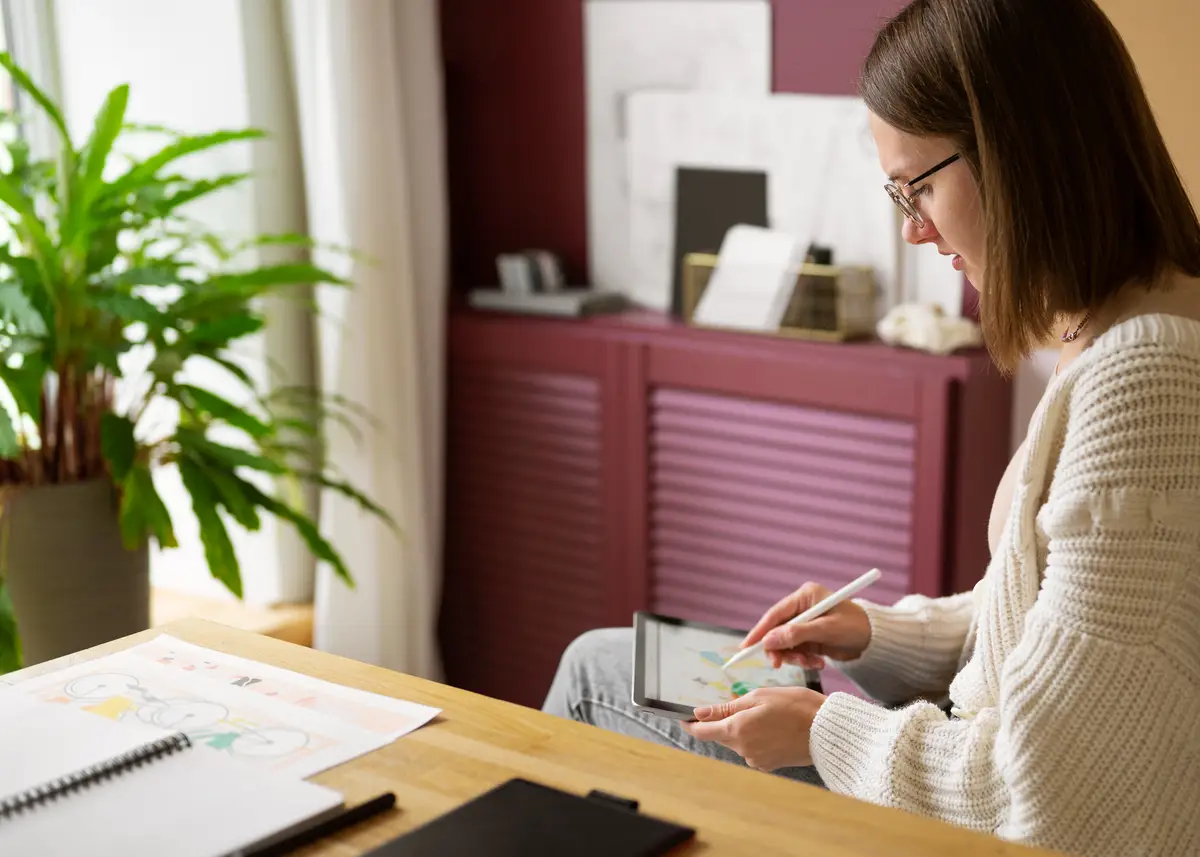 Adult female illustrator working on tablet device