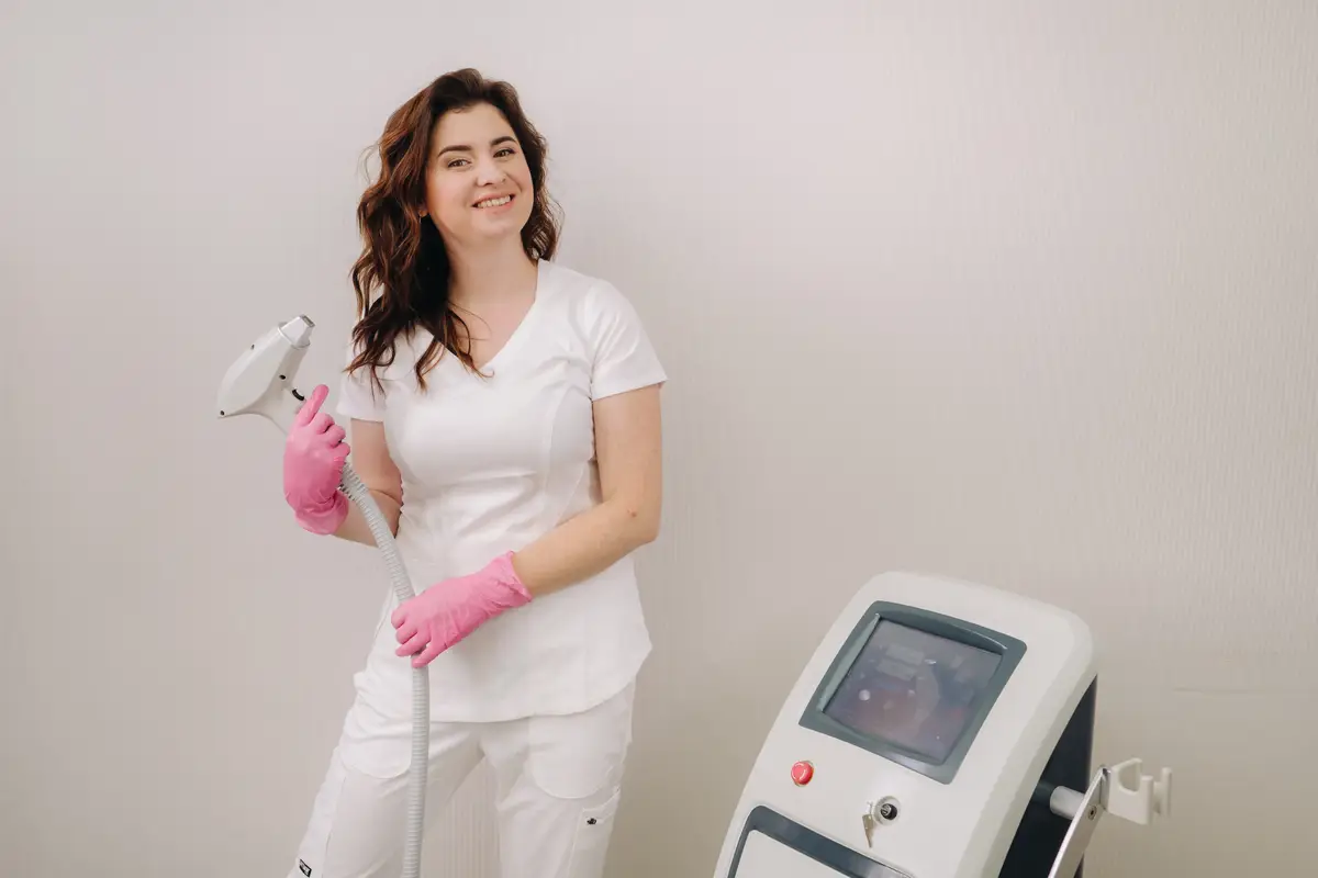 Portrait of the master of laser hair removal A woman in a white coat holds a laser hair removal device in her hands