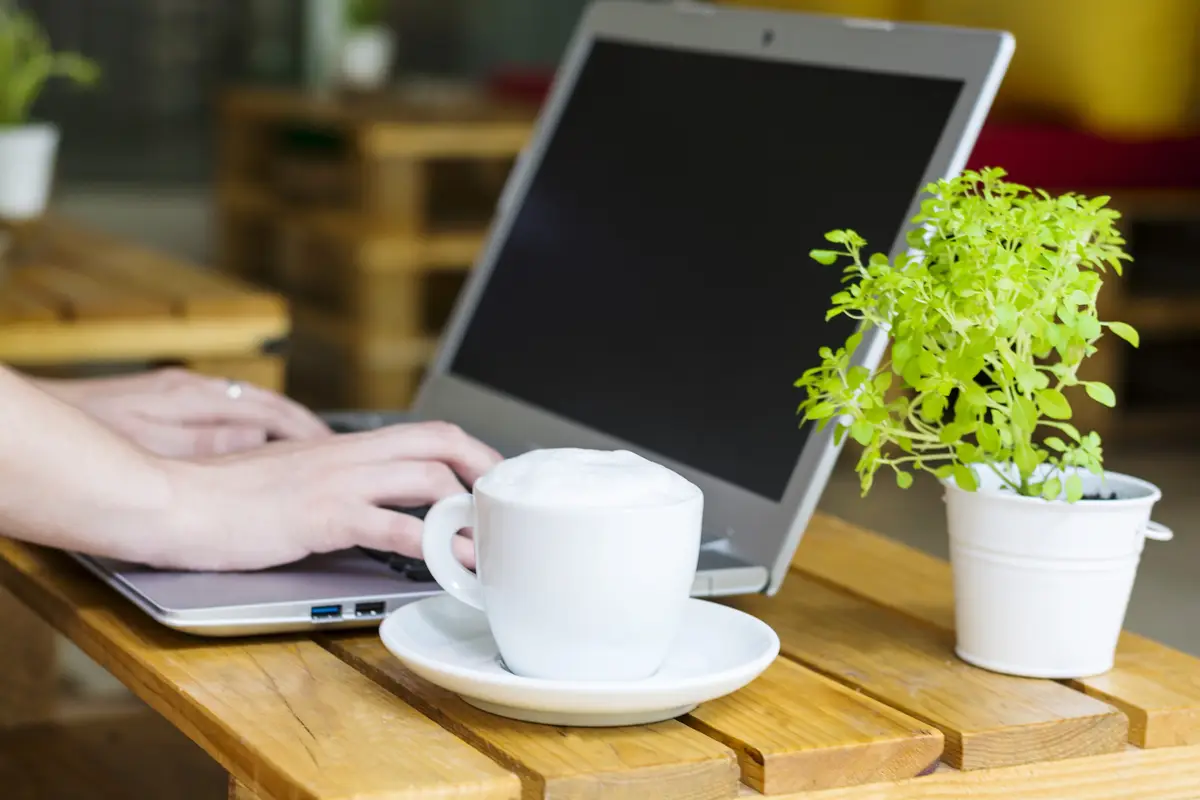 Hand holding coffee cup on table