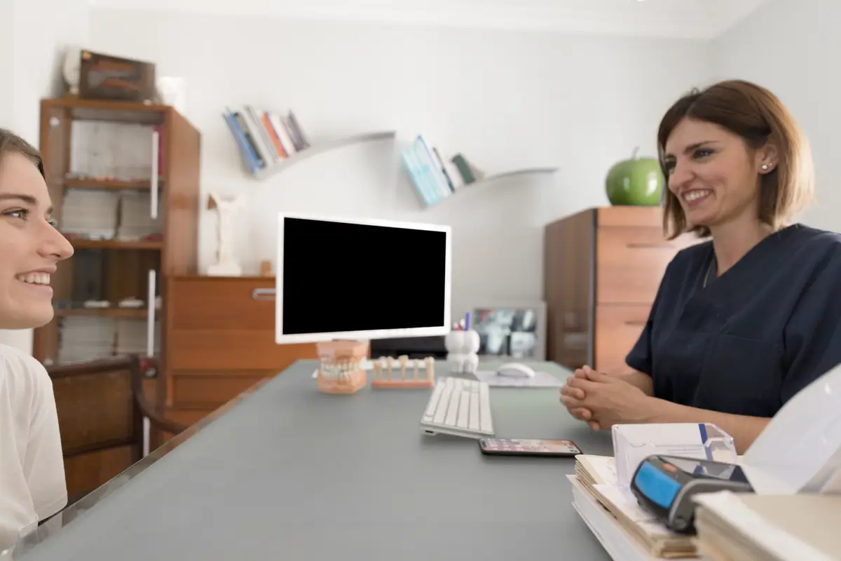Smiling patient consulting to dentist at dental clinic