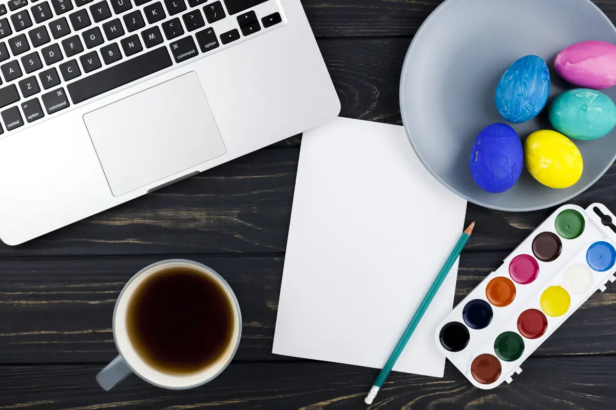 Easter eggs and watercolor near laptop
