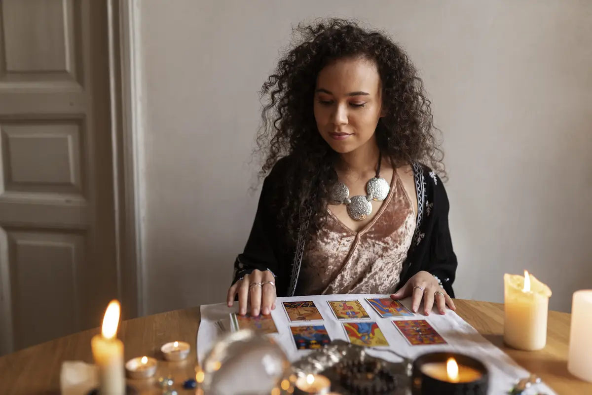 Medium shot woman reading tarot at home