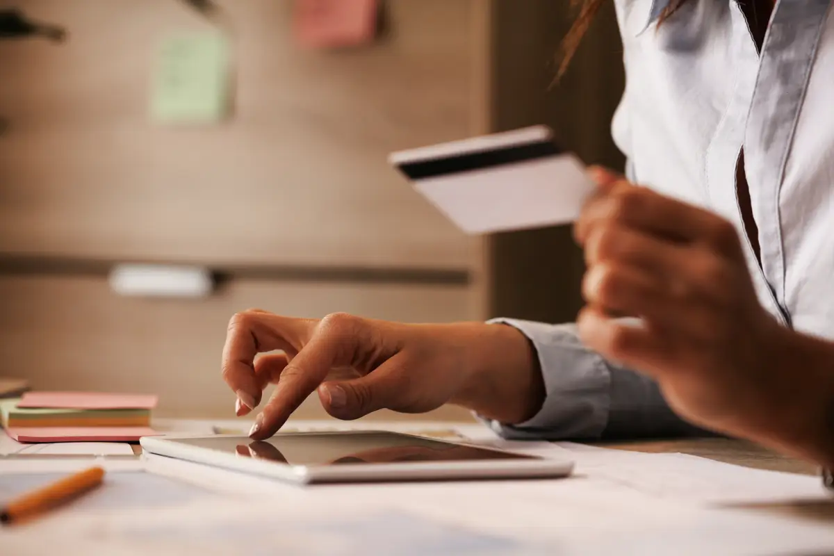Crédito empresarial nos EUA: Como construir do zero em 2026 2 Closeup of businesswoman using digital tablet and credit card while checking her online bank account