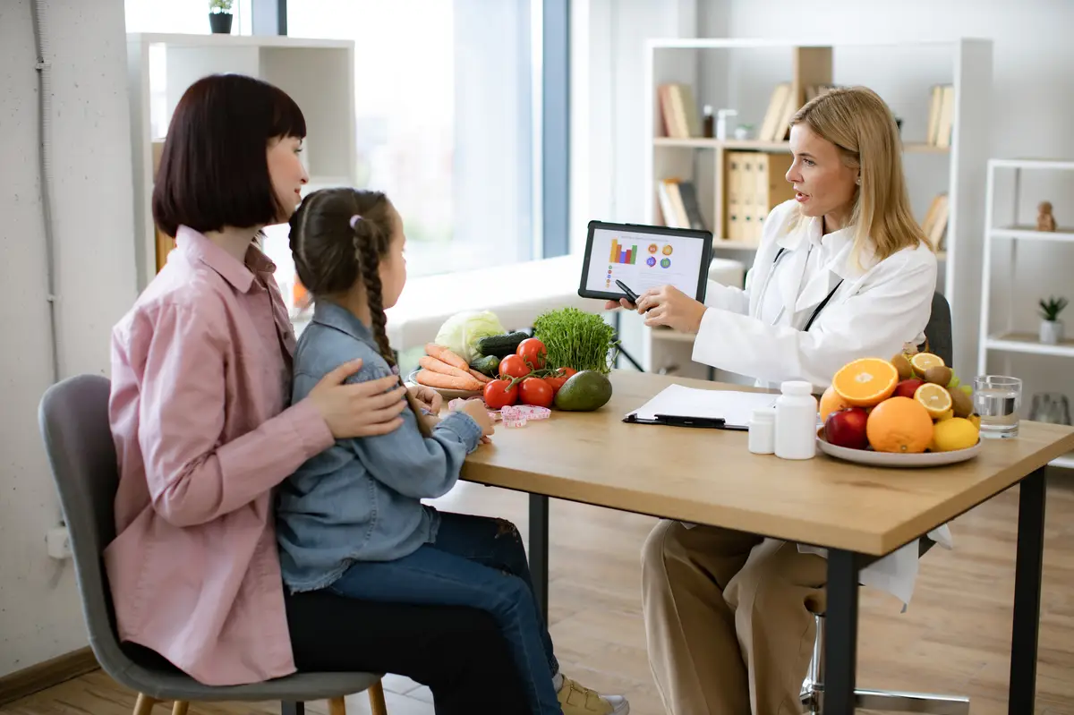 Mature Caucasian female doctor shows on tablet graphs of food for healthy eating