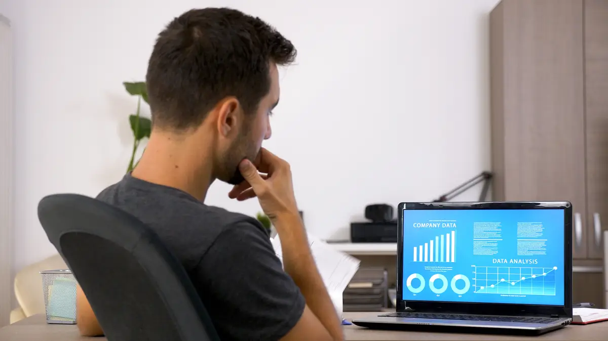 Business man with beard working hard at his desk in the office. Motivated young man .