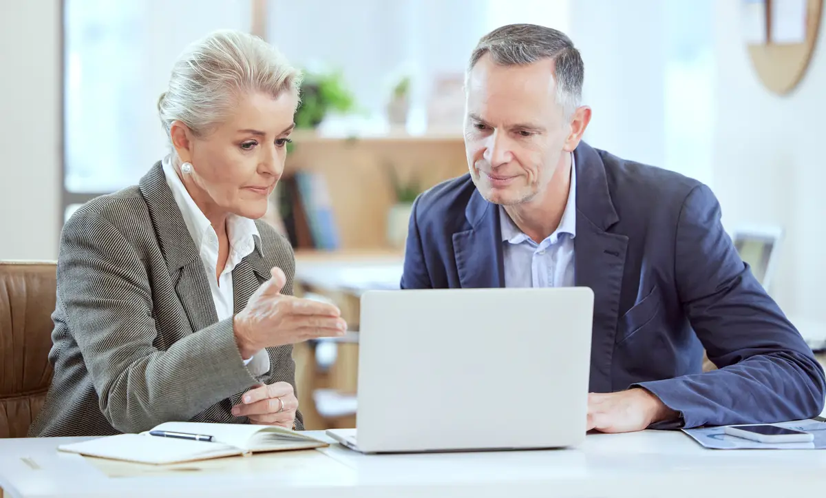 This is what were working with Shot of two businesspeople using a laptop together in an office at work