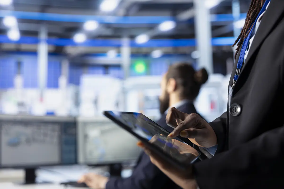 Photovoltaic plant worker adjusting manufacturing parameters on tablet close up