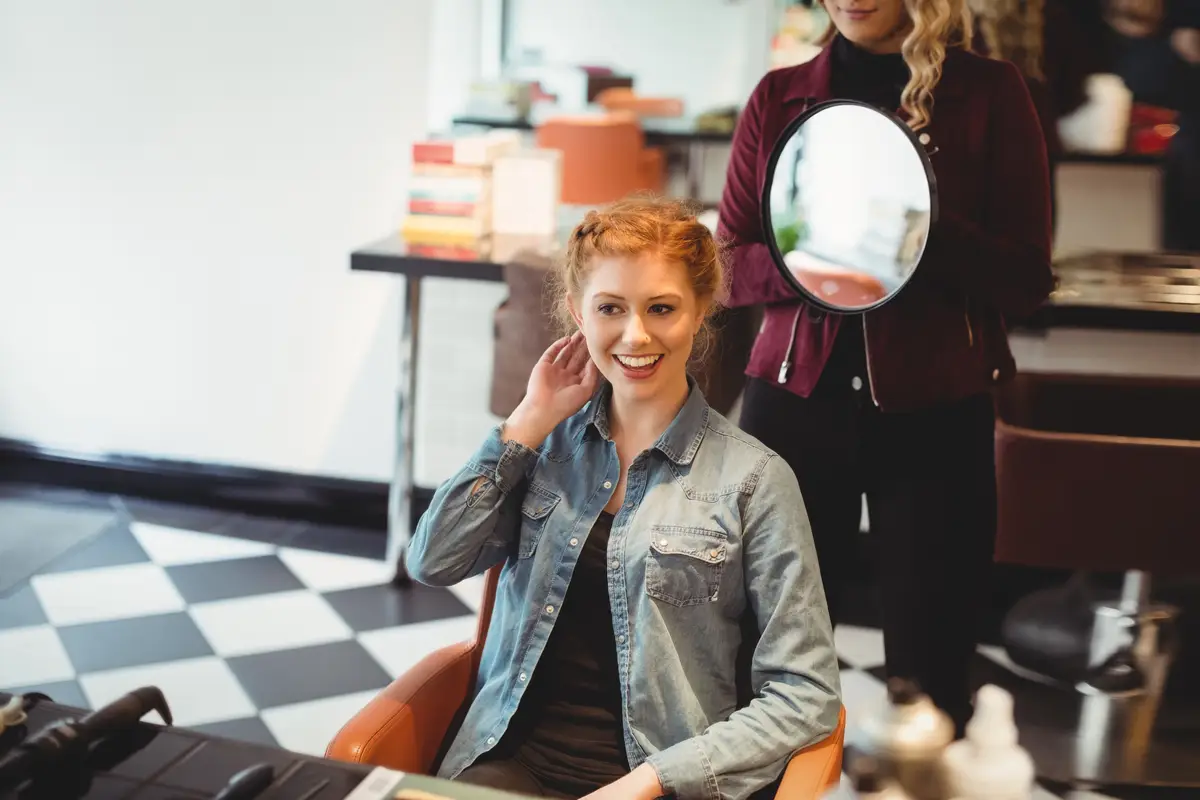Female hairdresser styling clients hair