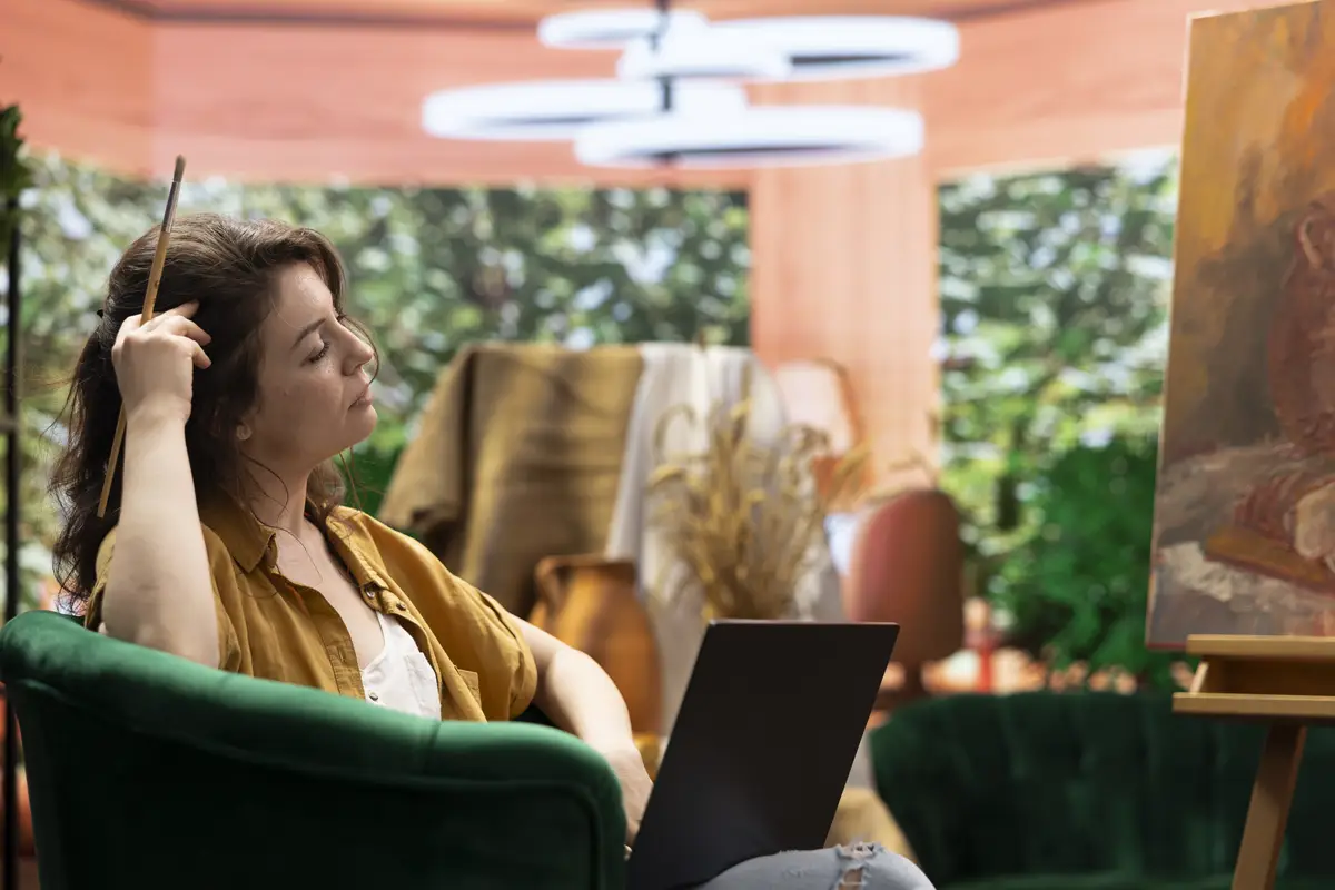 Female artist searching for a new painting inspiration on laptop