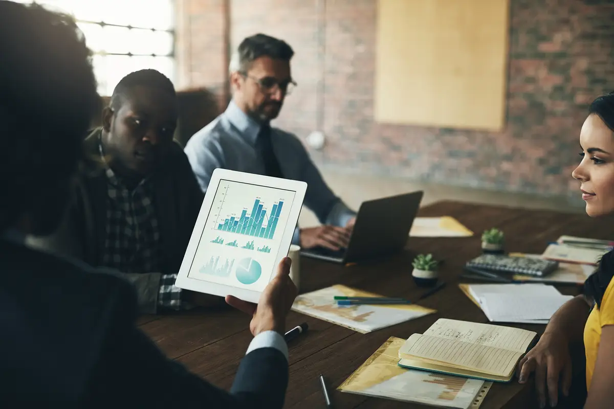 Graphs tablet or business people in meeting discussion or collaboration for company data analytics or growth Teamwork screen or budget analyst planning info for feedback report or charts stats