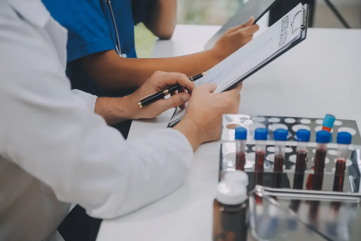 Avaliação clínica do escore VIRSTA no risco de endocardite 1 Medical worker in lab coat and sterile mask doing a microscope analysis while her colleague are working behind