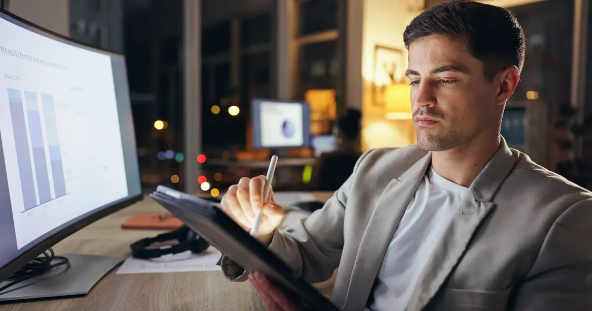 Businessman working and night workplace with tablet statistical analyst and analyzing project or sales report on computer Online graphs and internet research overtime and email stats in office