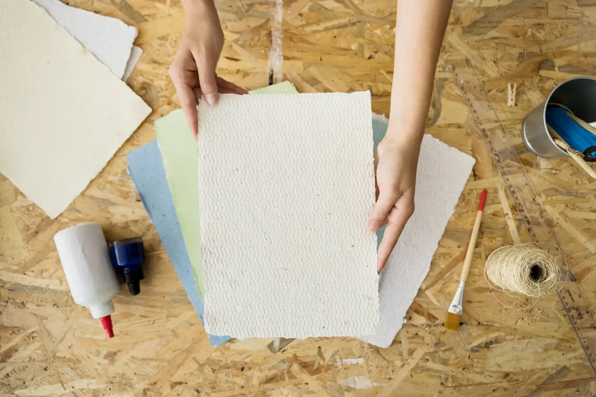 Elevated view of a woman's hand holding handmade paper