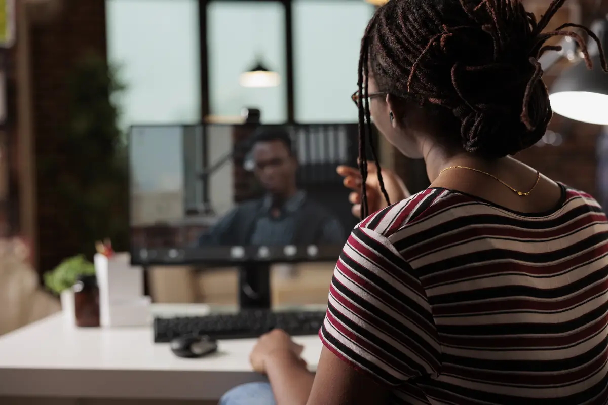 Woman talking with employee on videoconference, african american freelancer working from home. Remote worker attending virtual meeting, chatting on teleconference using computer