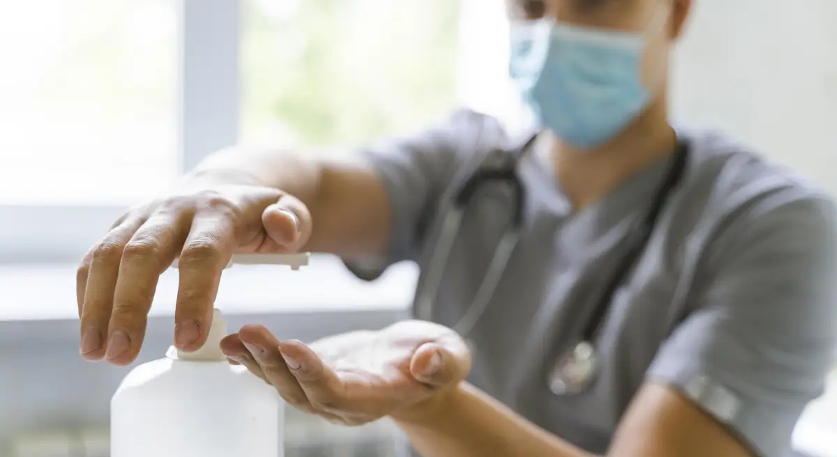 Garantindo acessibilidade: dispensadores de álcool em gel no ambiente hospitalar 1 Doctor with medical mask using hand sanitizer