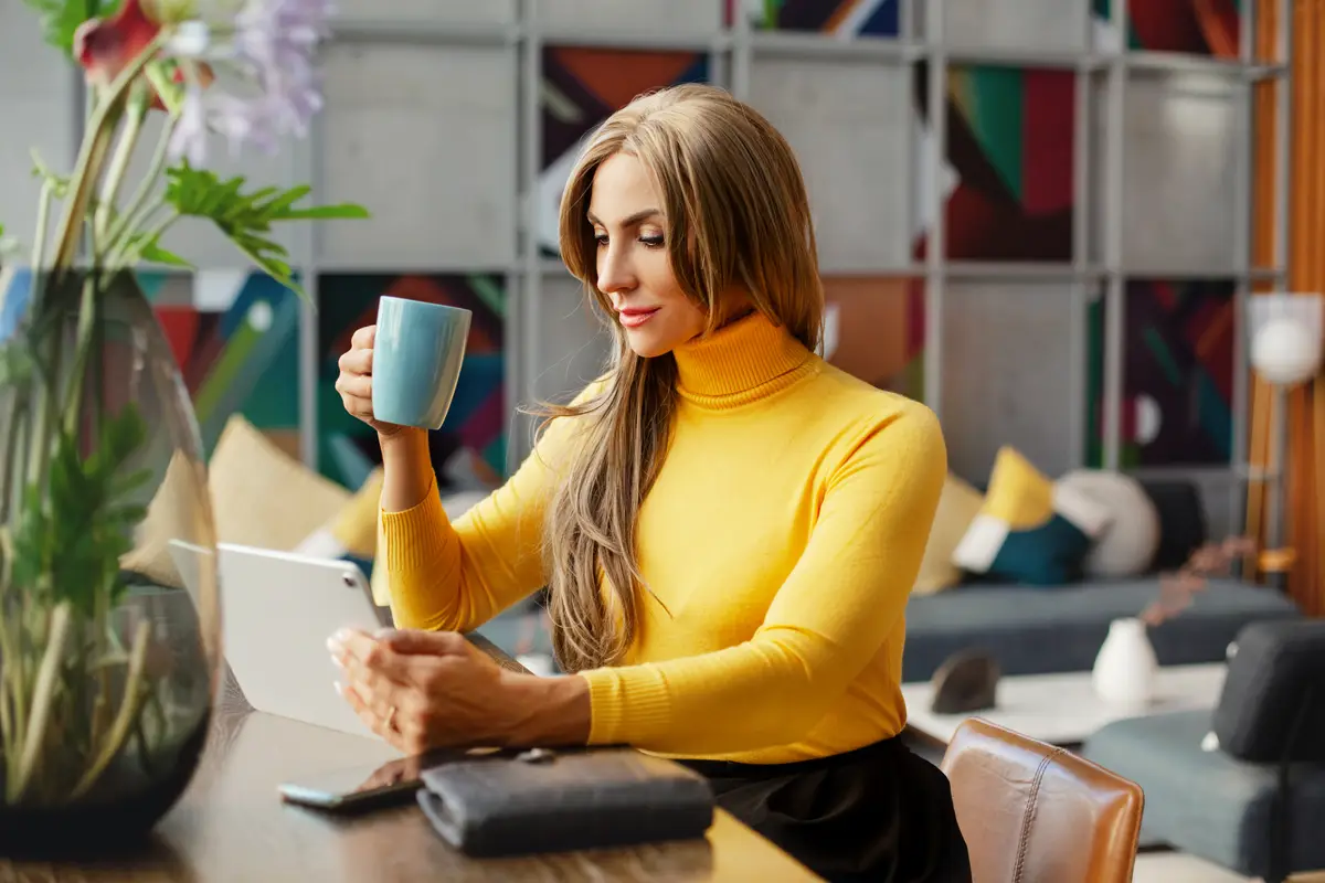 Portrait of a beautiful businesswoman enjoying coffee while working on a tablet