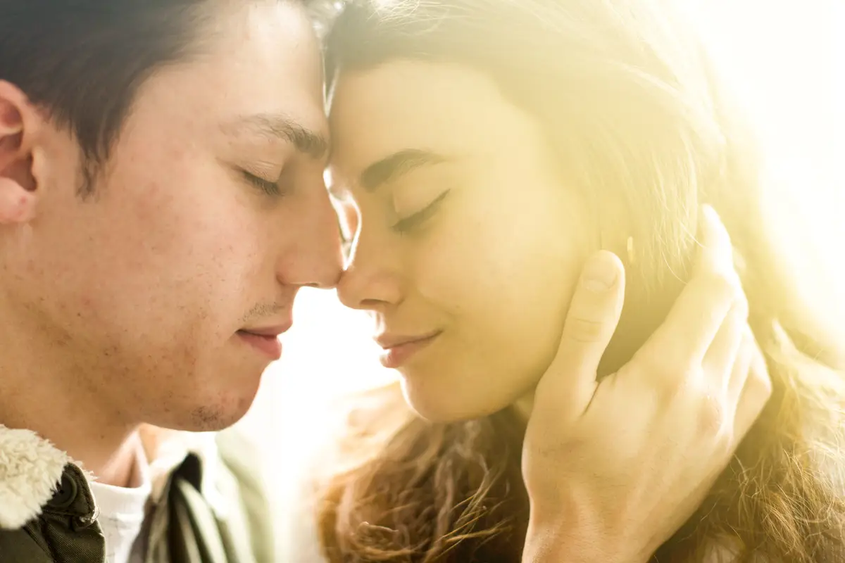 Close-up of young couple standing face to face with closed eyes