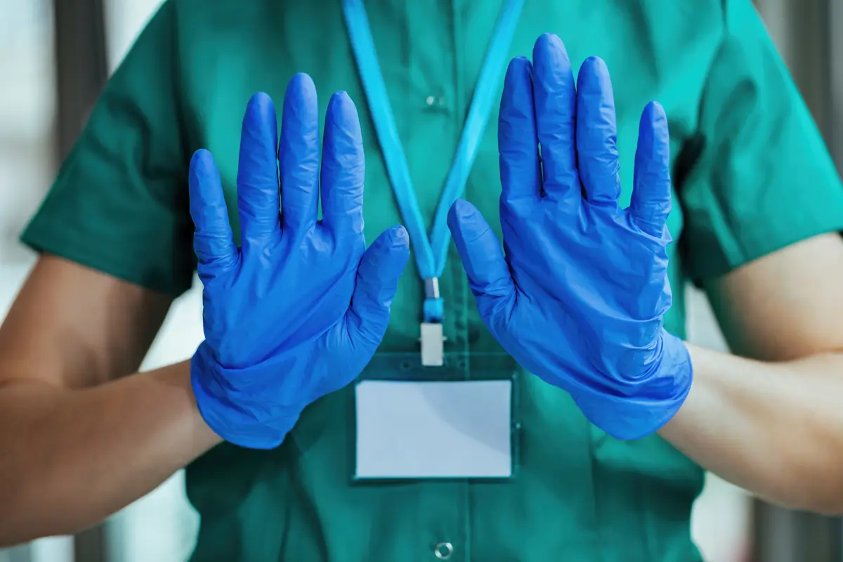 Diagnóstico e tratamento ideais da peritonite fúngica na diálise 3 Unrecognizable nurse wearing protective gloves while gesturing stop sign with her hands