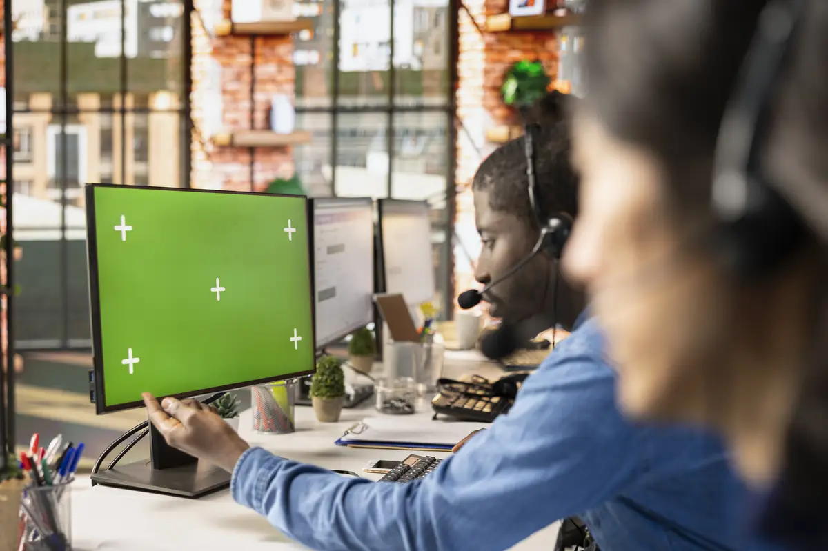 Call center agent at green screen PC answering customers technical inquiries