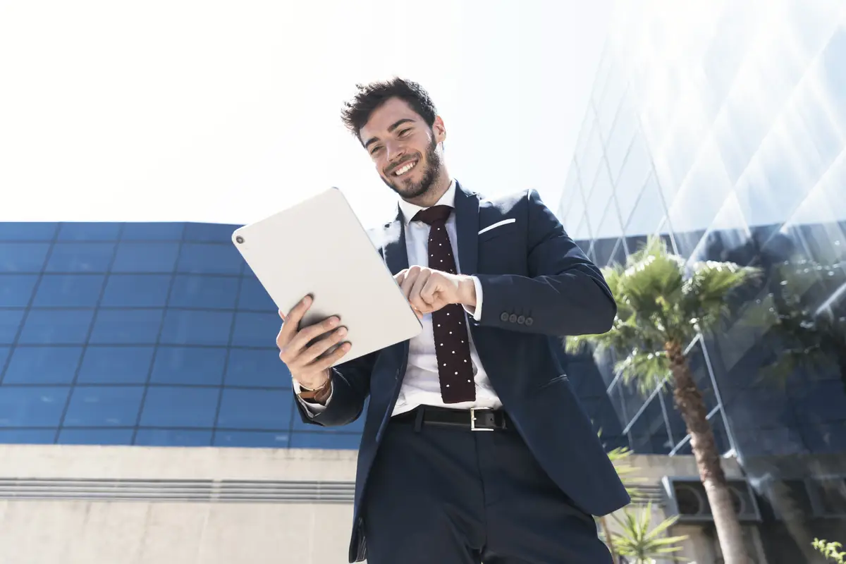 Low angle smiley man with his tablet