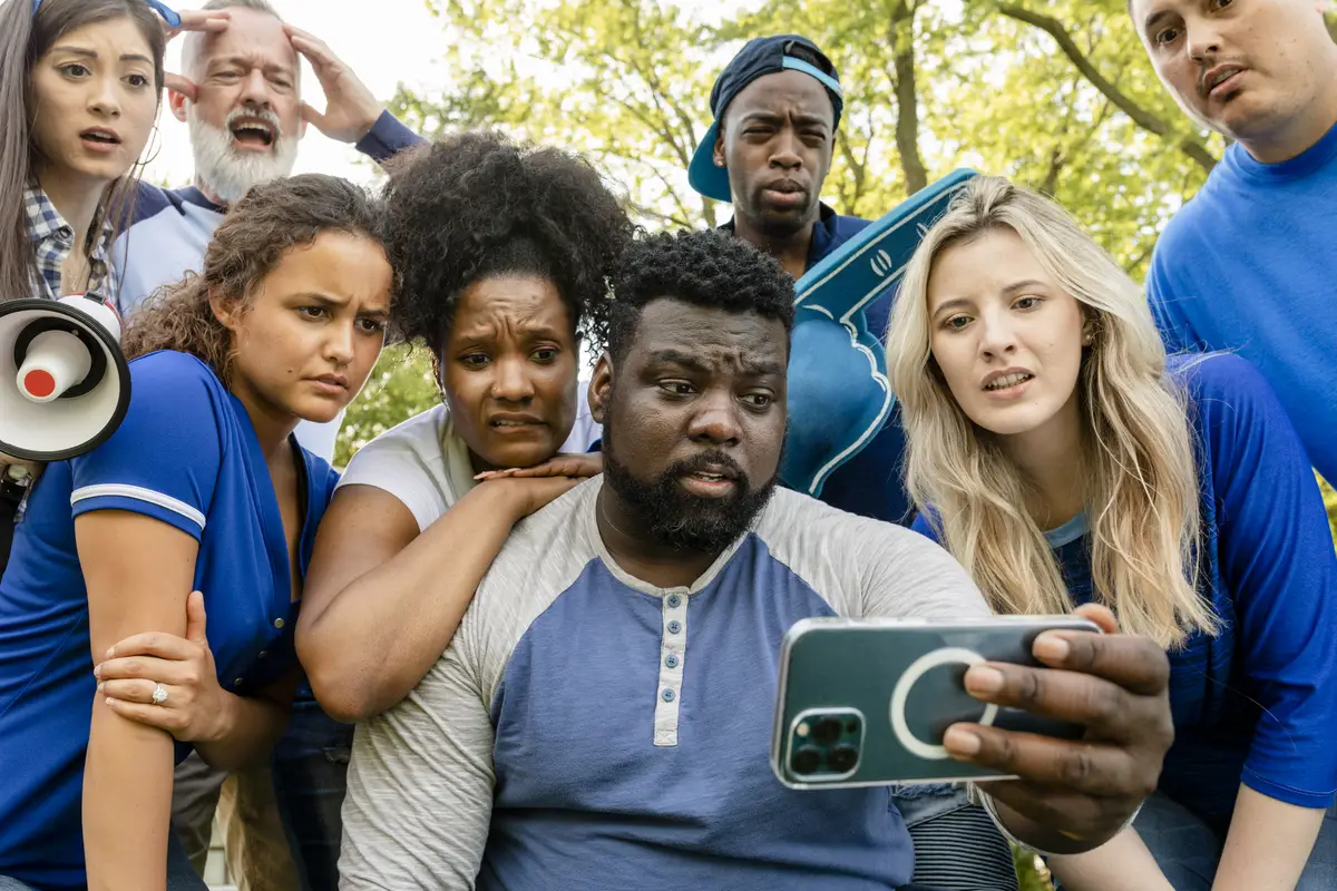Baseball supporters watching their team lose the game on a phone