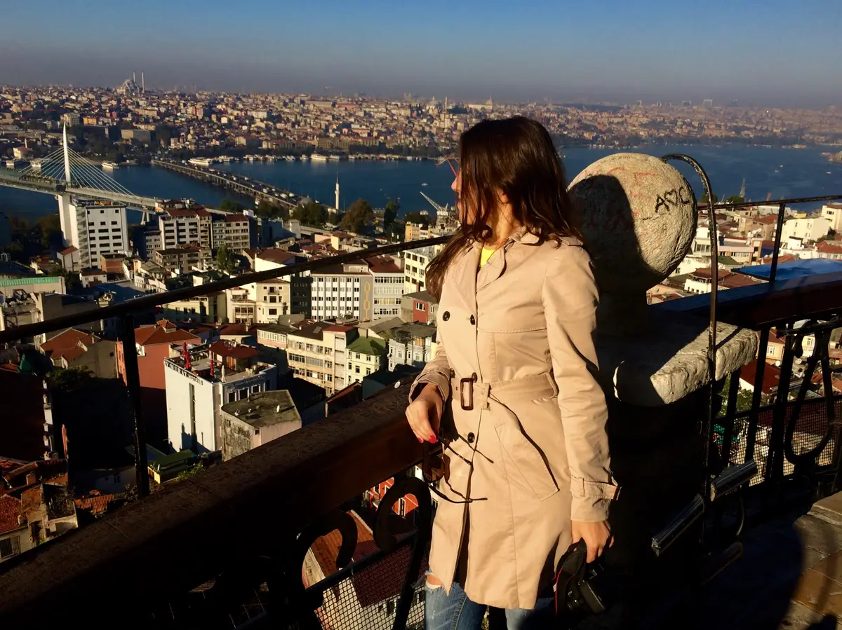 Woman at observation point looking towards cityscape on sunny day
