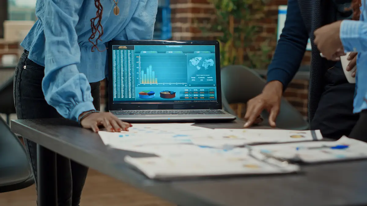 Coworkers examining reports on papers, looking at statistics and annual data analytics to increase profit. Workers group planning research strategy with documents for business development.