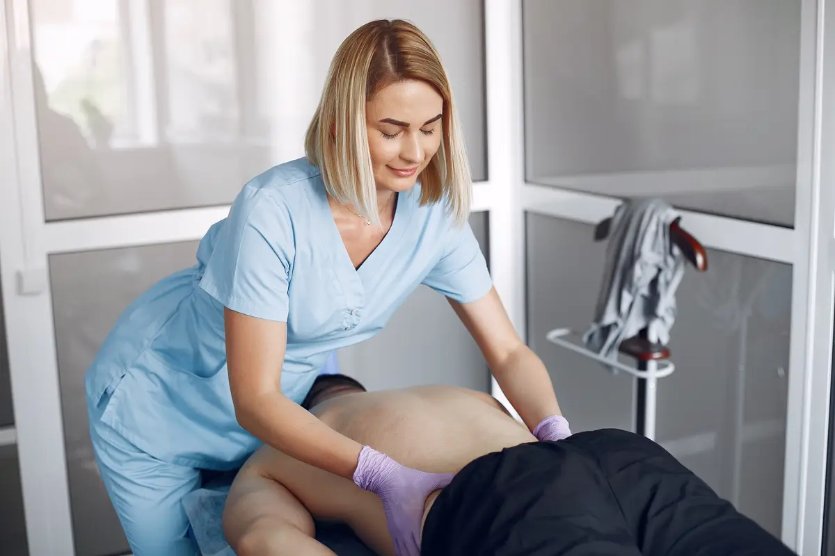 The doctor massages the man in the hospital