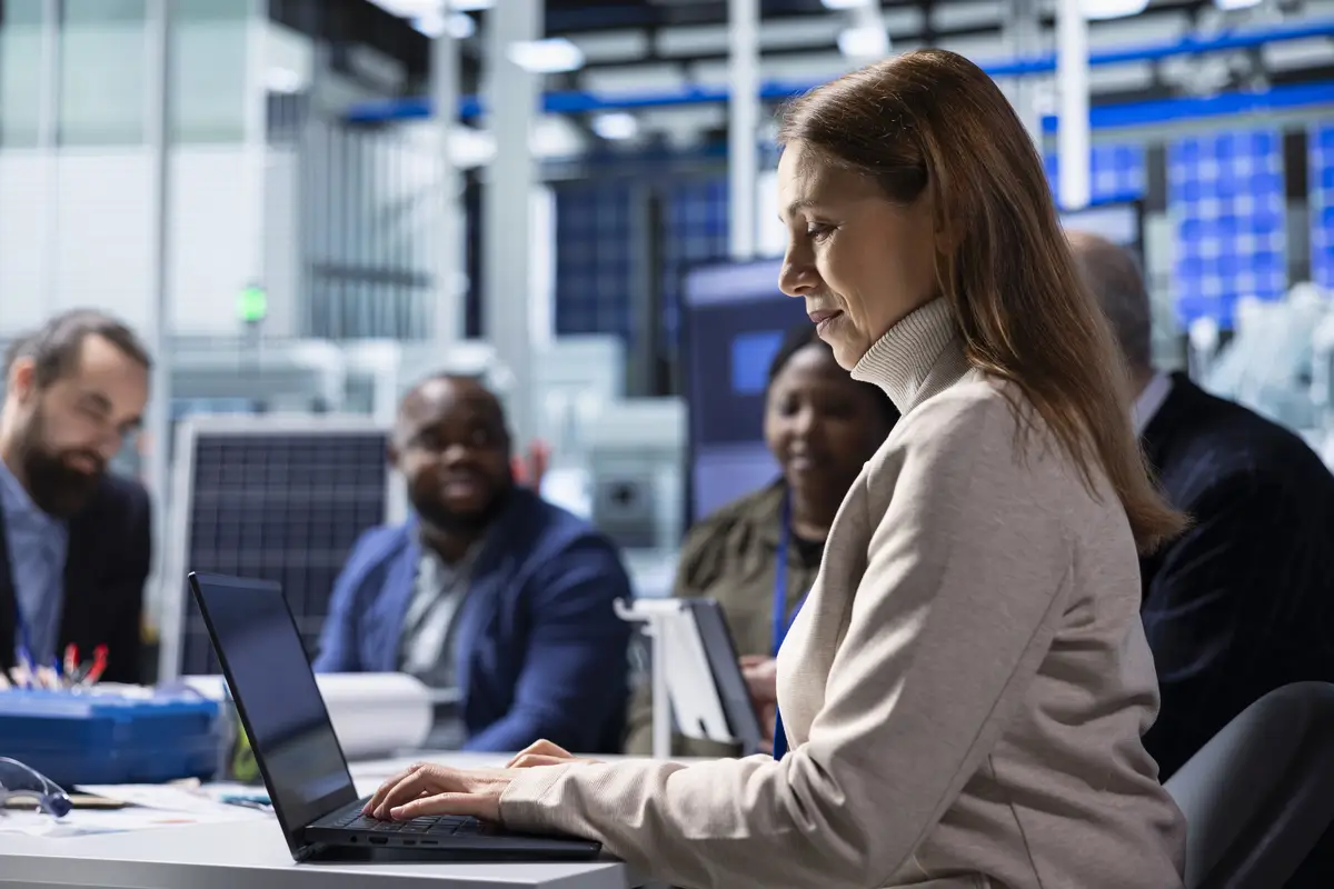 Photovoltaics factory management team analyzing data using laptop