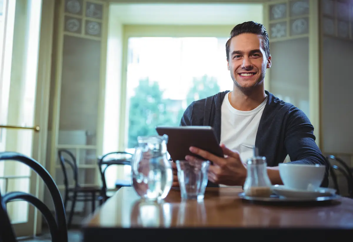 Portrait of man using digital tablet in café