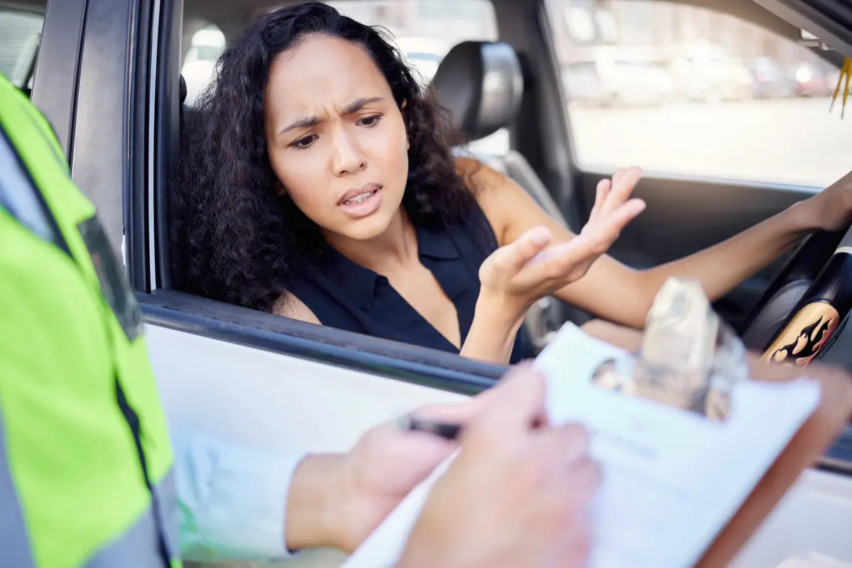 What exactly did I do wrong Shot of a young businesswoman looking upset at receiving a ticket from a traffic officer