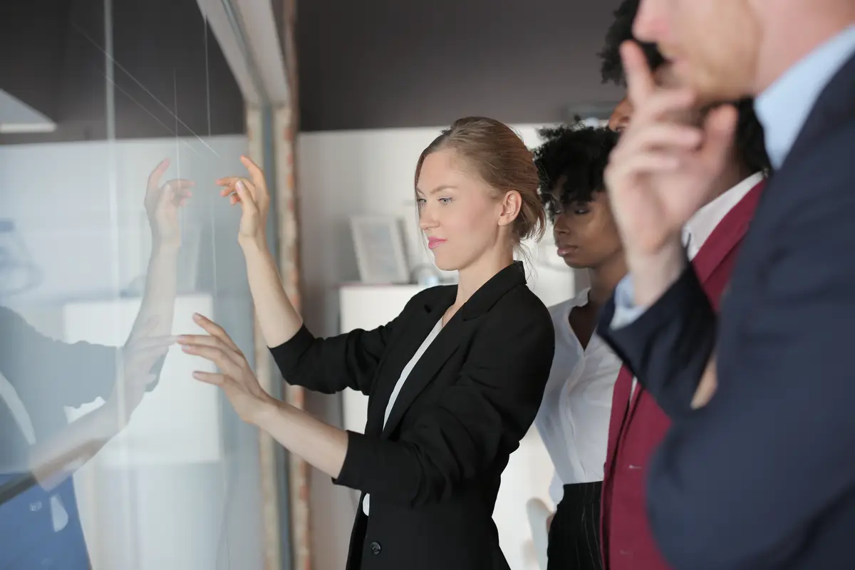 Successful female team leader in a formal outfit presenting the new project to multiethnic partners