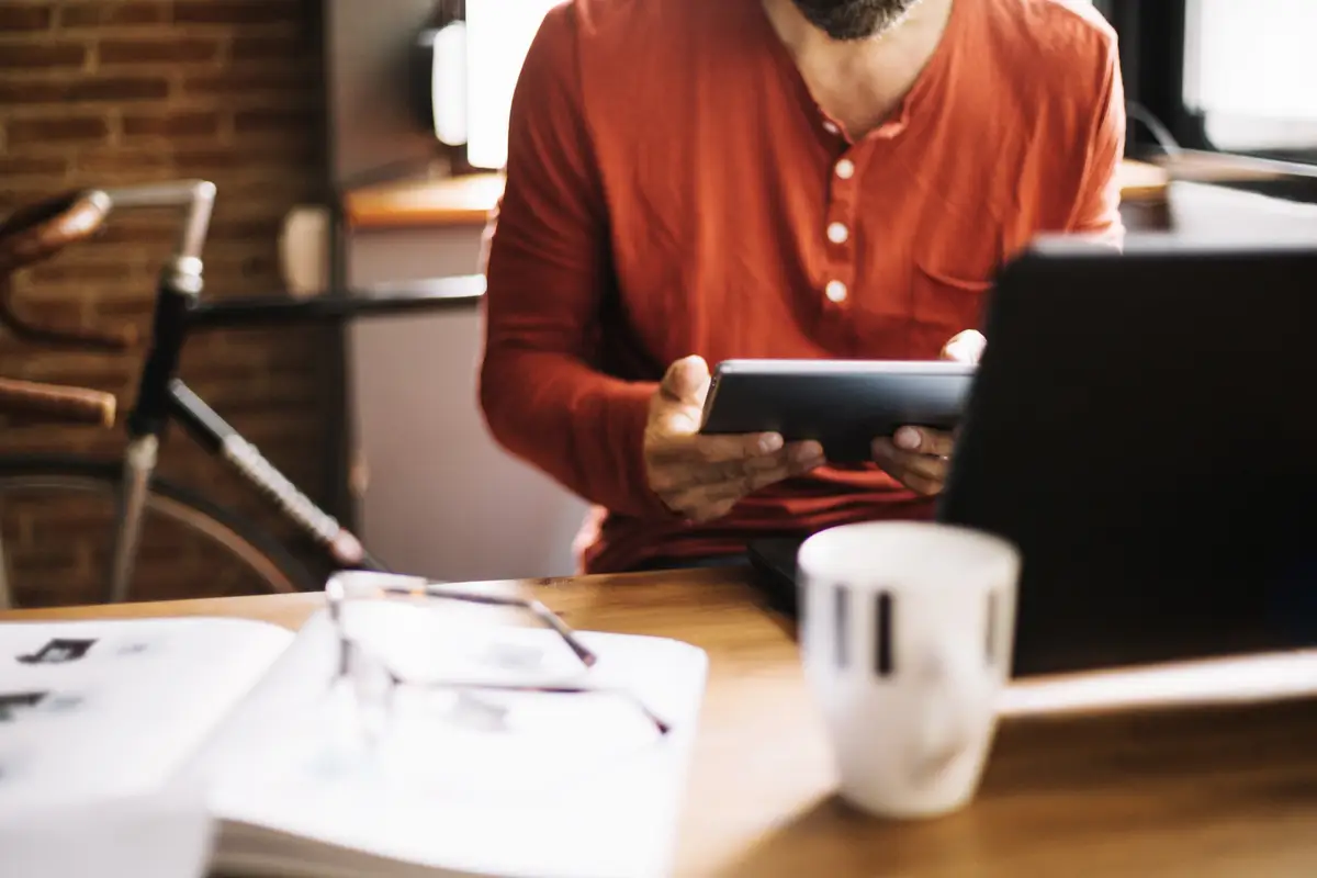Crop man at workplace with gadgets
