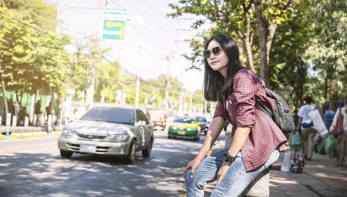 Beautiful woman looking away while standing on road