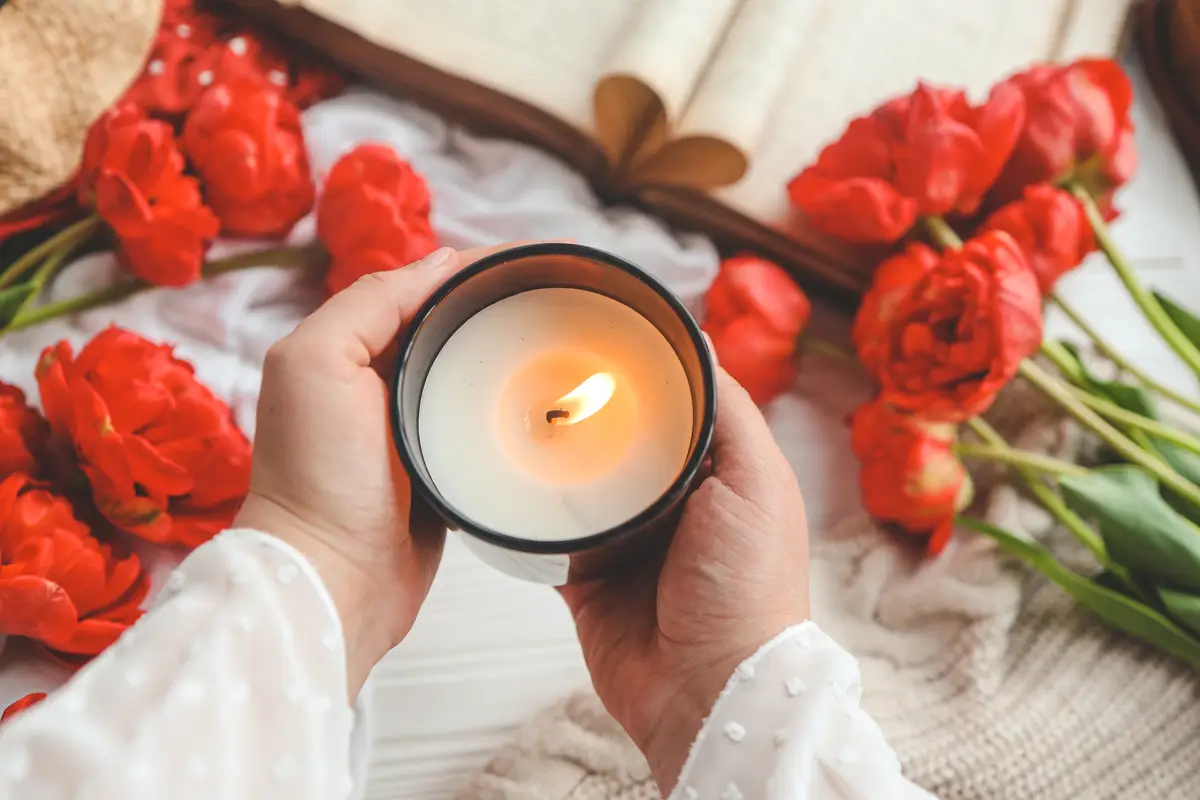 Burning candle in hands aesthetics