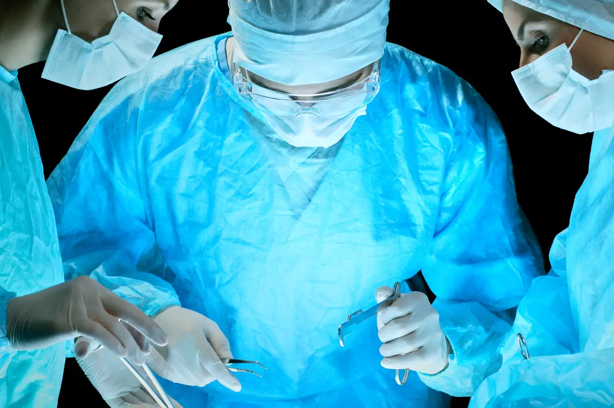 Infecções cutâneas por micobactérias não tuberculosas em imunocompetentes 4 Medical team performing operation. Group of surgeon at work in operating theatre toned in blue.