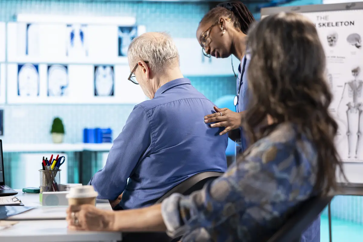 African american specialist evaluates the body posture of old man