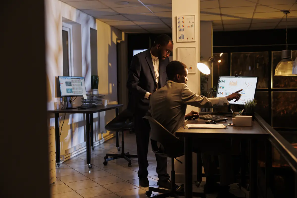 Executive managers looking at marketing statistics on computer