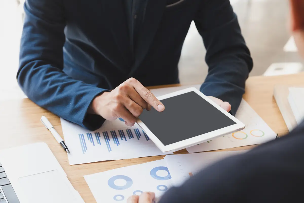 Midsection of man using digital tablet on table in office