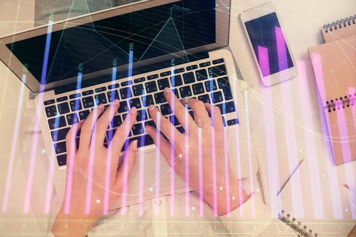 Double exposure of woman hands working on computer and forex chart hologram drawing Top View Financial analysis concept