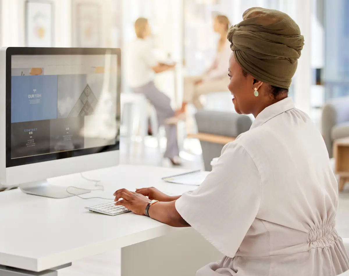 Administration corporate and business woman typing on computer at her desk in digital marketing company office building Advertising branding and vision with black woman working at a digital agency