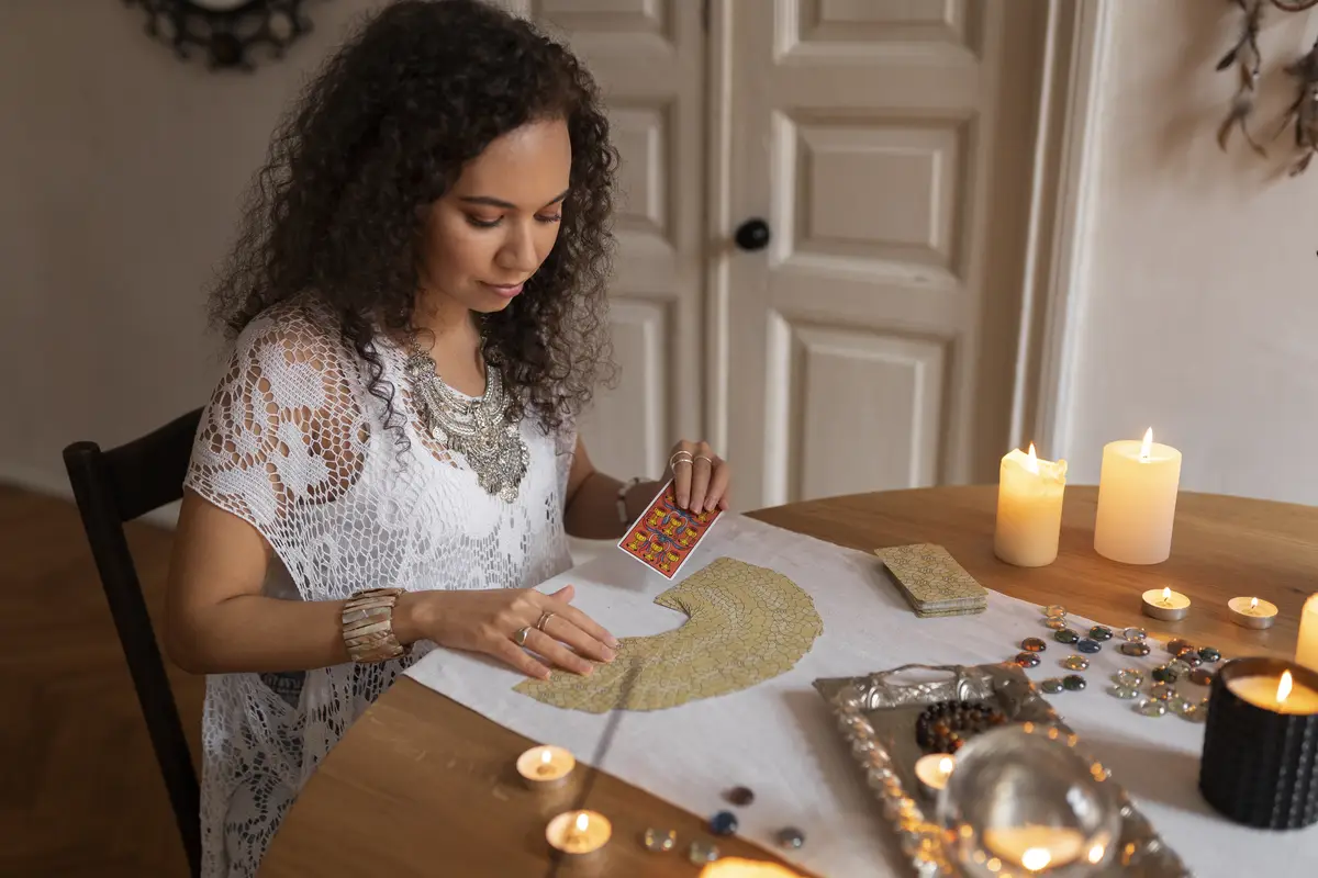 Medium shot woman reading tarot at home