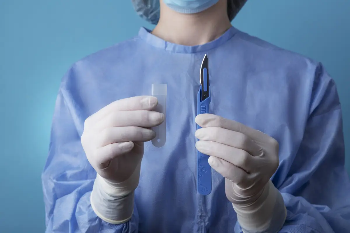 Female doctor holding metallic medical scalpel