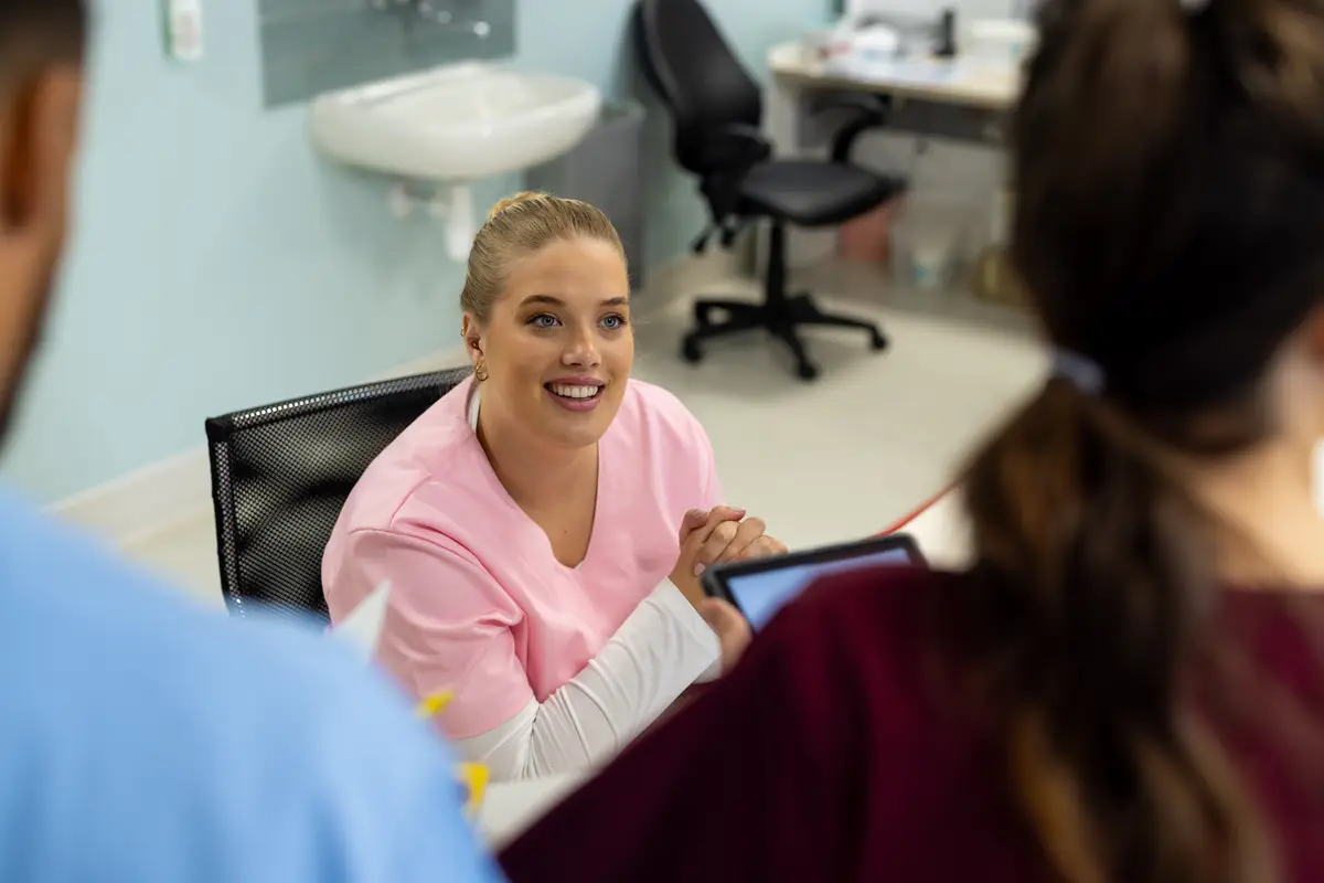 Diverse doctors talking at reception desk at hospital