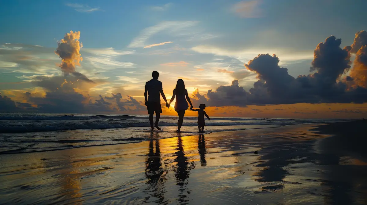 A family of mixed races walking hand in hand their silhouettes cast on the beach at sunrise