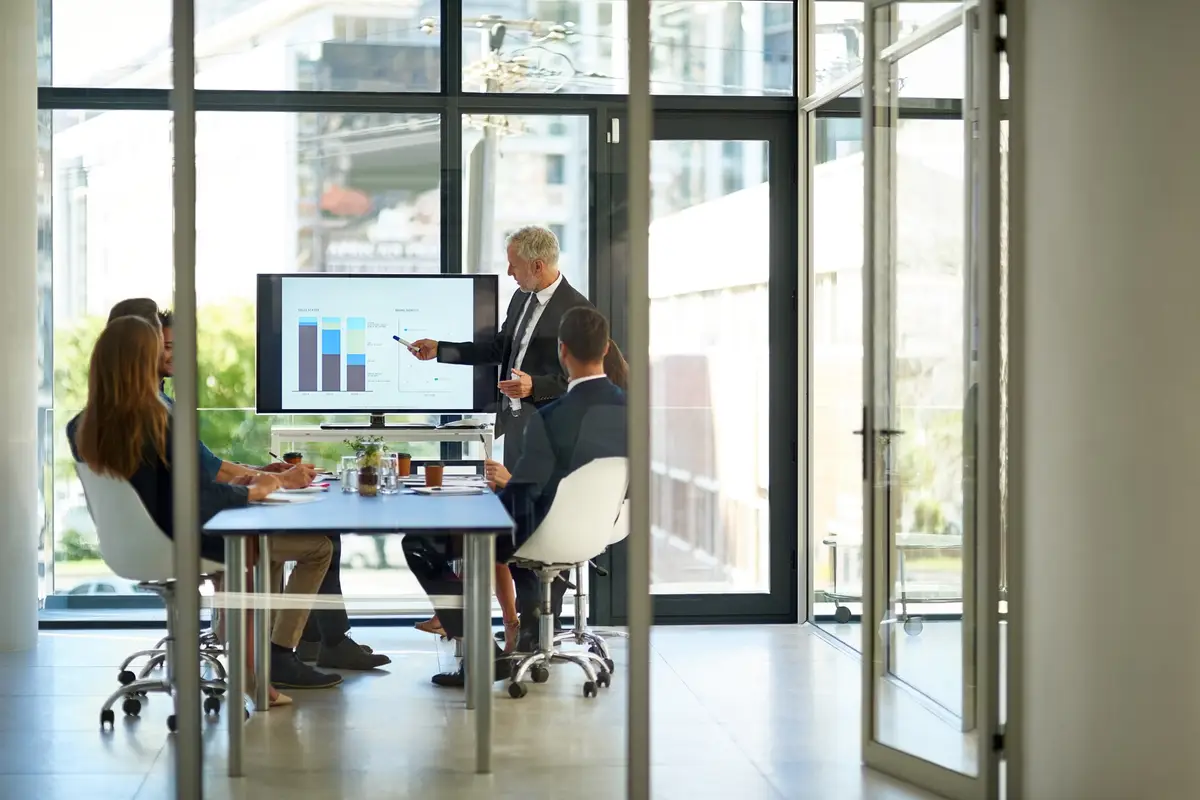 Office meeting and business people with graph on screen for investment growth and solution Boardroom window data analyst and manager with workshop for trading portfolio kpi analysis and report