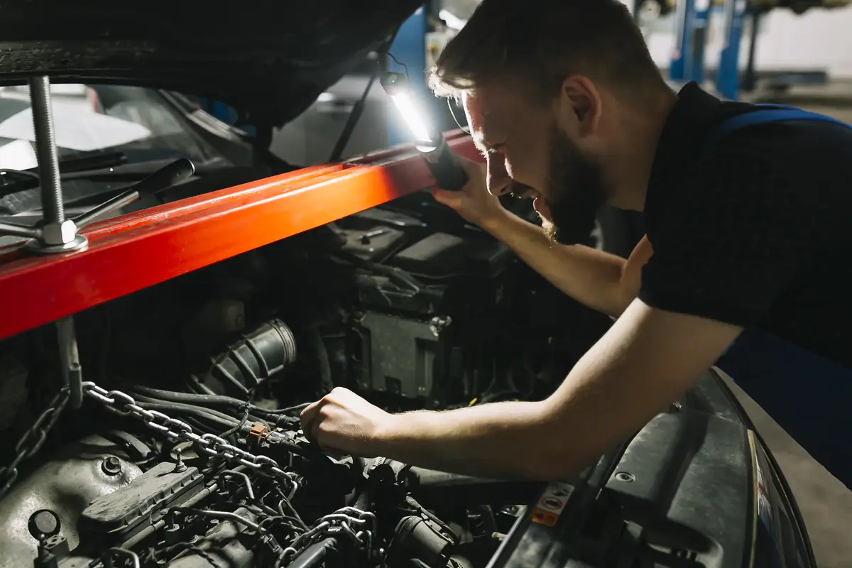 Auto mechanic looking car's engine